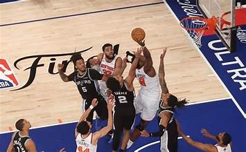 A basketball player jumps to make a shot while surrounded by several defenders during an intense game.