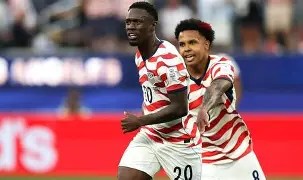 Two soccer players celebrating during a match, wearing red and white striped jerseys with the number 20 visible.